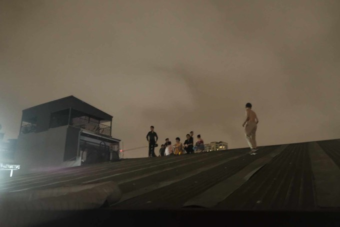 Người dân trèo lên mái nhà chờ giải cứu. Ảnh: Nguyễn Hoàng Giang