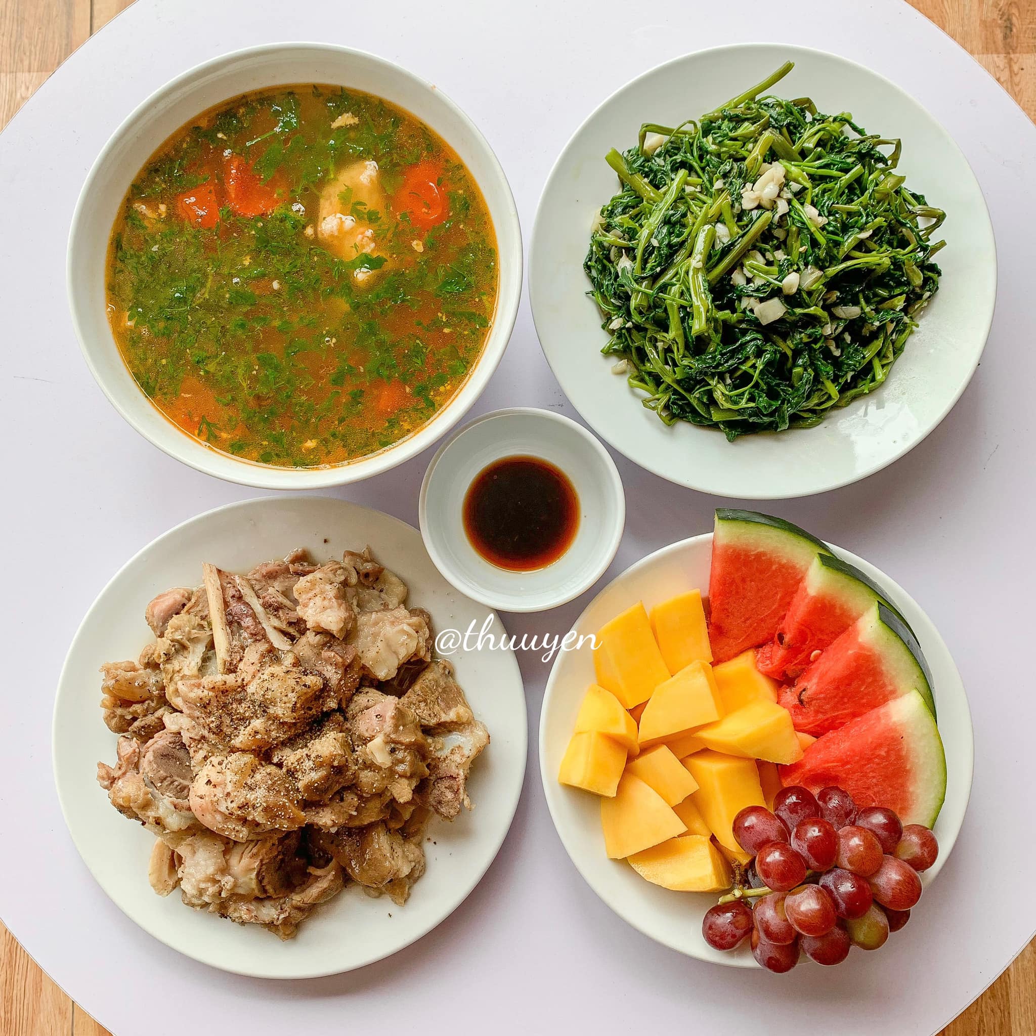 Canh xương cà chua, thịt hầm, rau muống xào, trái cây.