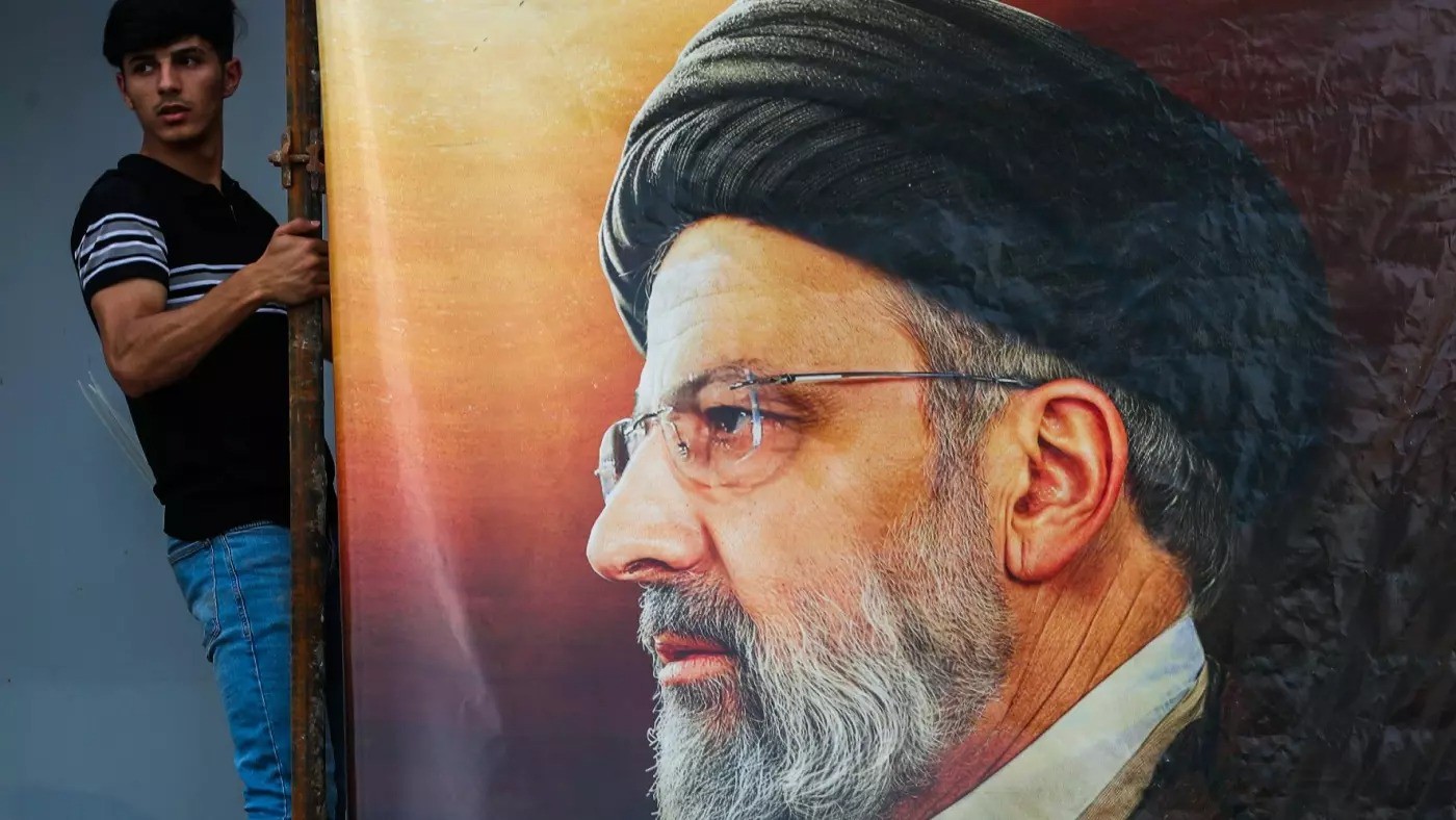 Một người treo bức chân dung lớn của cố Tổng thống Iran Ebrahim Raisi bên ngoài Đại sứ quán Iran ở Iraq ngày 20/5/2024. Ảnh: AFP