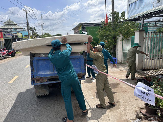 Các lực lượng hỗ trợ người dân di dời tài sản khỏi khu vực sạt lở.