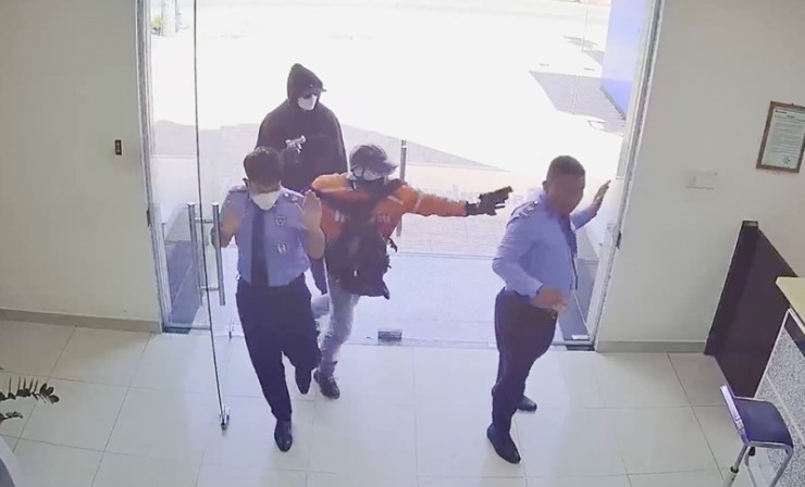 Nhân viên bảo vệ ngân hàng bị hai tên cướp dùng súng giả khống chế.