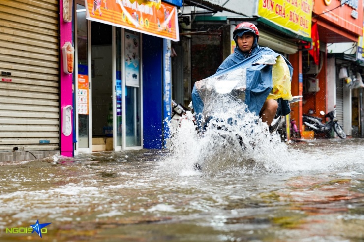 Một người dân cố gắng tăng ga xe máy để phóng qua những đoạn ngập sâu nhất.