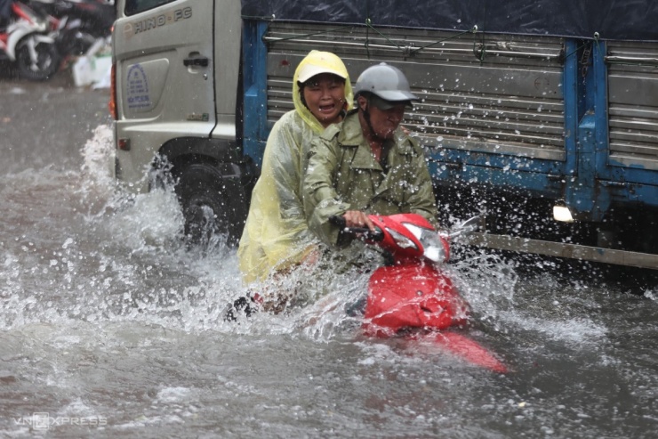 Khoảng 11h30, mưa lớn kèm gió giật, sấm chớp xảy ra tại nhiều quận huyện ở TP HCM khiến hàng loạt khu vực ngập nặng.