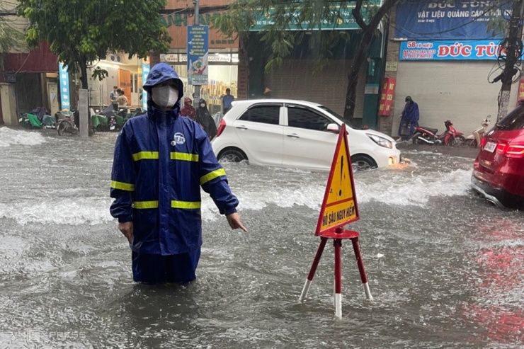 Đường Tô Hiệu, quận Lê Chân có đoạn ngập  lút bánh xe. Từ 3h, công nhân thoát nước túc trực khơi thông cống rãnh, đặt cảnh báo ở những điểm ngập sâu. Các mương, hồ điều hòa xuống cũng được hạ  mực nước thấp nhất có thể để nước rút nhanh.