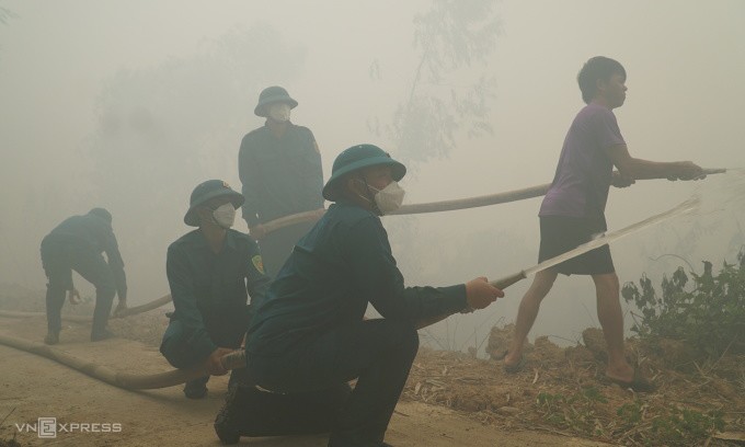 Lực lượng cứu hộ dùng nước dập lửa. Ảnh: Phùng Tiên