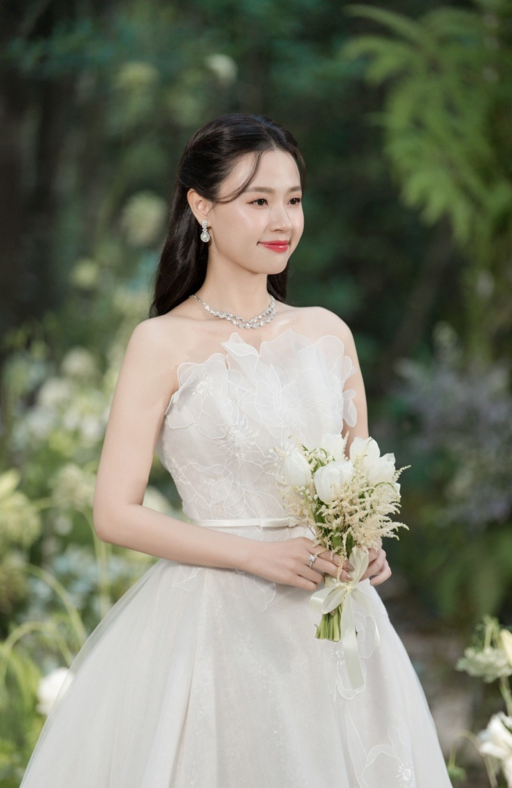 Nhà mốt sử dụng chất liệu organza, nhấn nhá một số chi tiết như bông hoa làm từ ren, trải dài khắp thân váy.