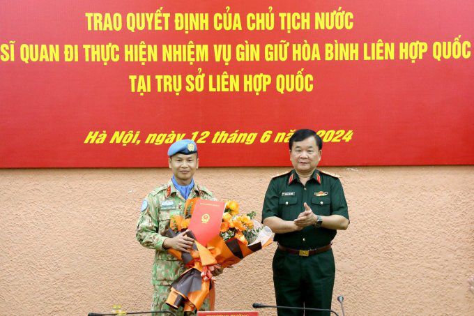 Thượng tá Trương Anh Tuấn nhận quyết định và hoa chúc mừng từ Thượng tướng Hoàng Xuân Chiến, Thứ trưởng Bộ Quốc phòng. Ảnh: Hoàng Phong