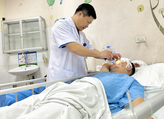 Bác sĩ Tuyển đang kiểm tra sức khỏe cho bệnh nhân nam bị tai nạn giao thông, ngày 12/6. Ảnh: Thùy An