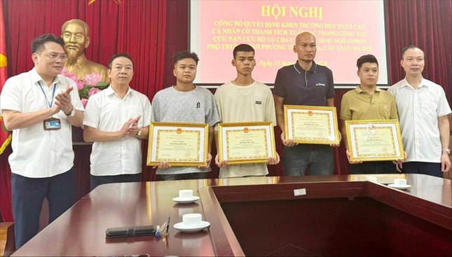 Các anh Nguyễn Kim Long, Phạm Quốc Luật, Hoàng Anh Tuấn, Đồng Văn Tuấn nhận khen thưởng từ chính quyền vì hành động dũng cảm cứu người trong vụ cháy. Ảnh: PV