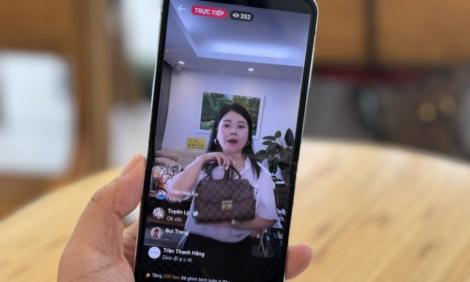 Nhân viên tại một shop thanh lý đồ hiệu đang livestream bán hàng qua nền tảng Facebook. Ảnh: Phương Dung