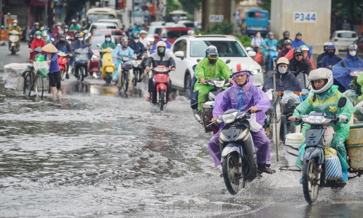 Người Hà Nội chật vật đi làm trong cơn mưa nặng hạt - 10