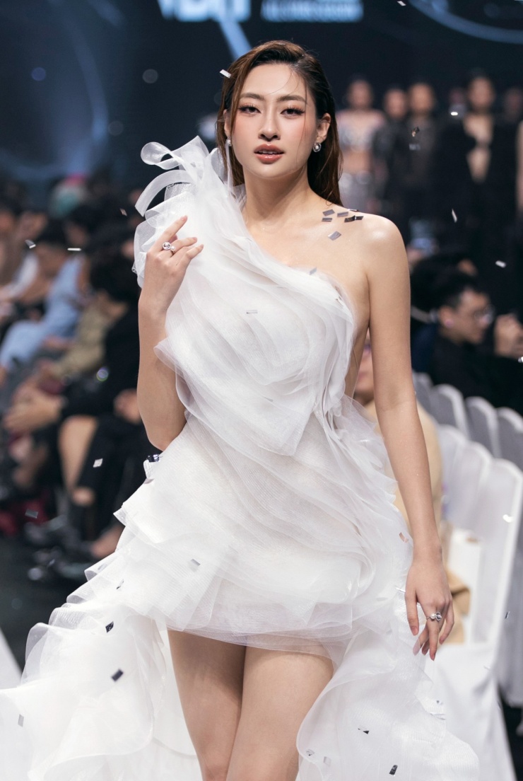 Hoa hậu Lương Thùy Linh mở màn với thiết kế đầm high-low, xếp lớp nhiều tầng voan, phần lưng hở sâu.