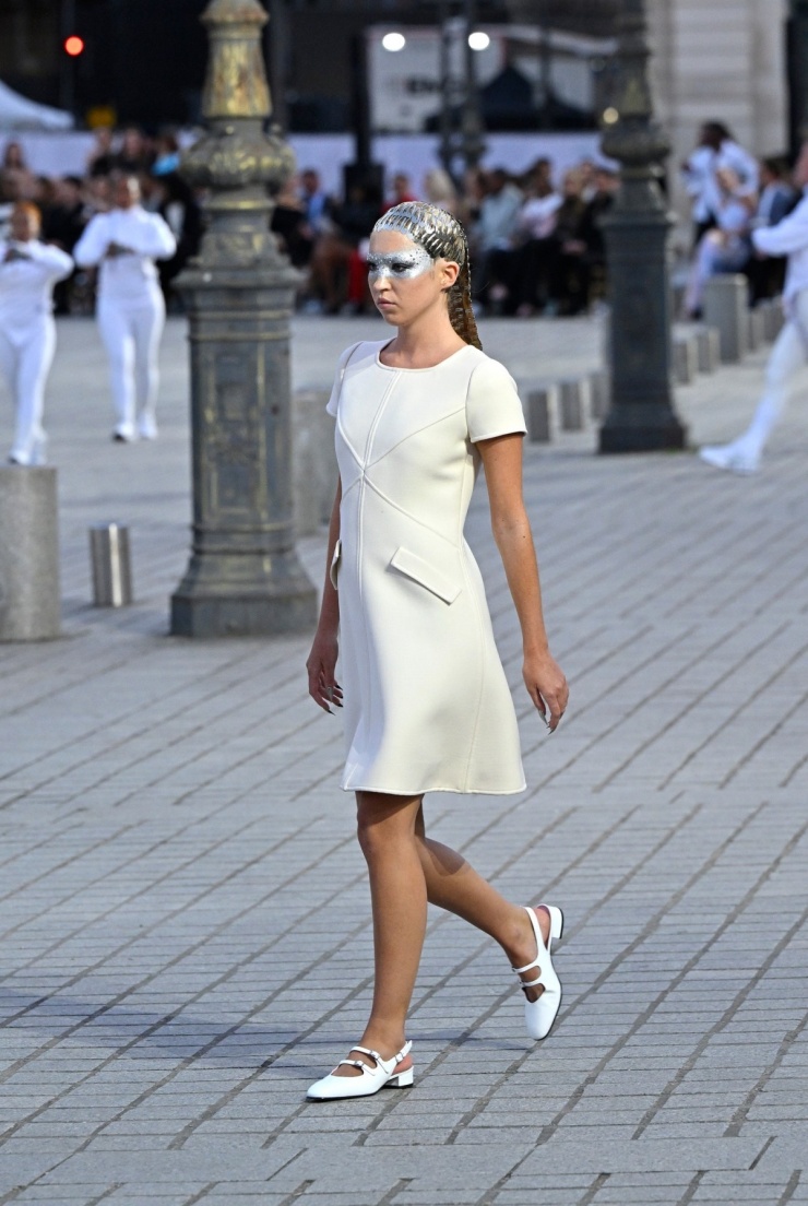 Lila Moss - con gái siêu mẫu Kate Moss - thể hiện chiếc váy midi tối giản của Courrèges và giày Carel. Trang phục tái hiện thời trang của thập niên 1960, tôn vinh môn đấu kiếm.
