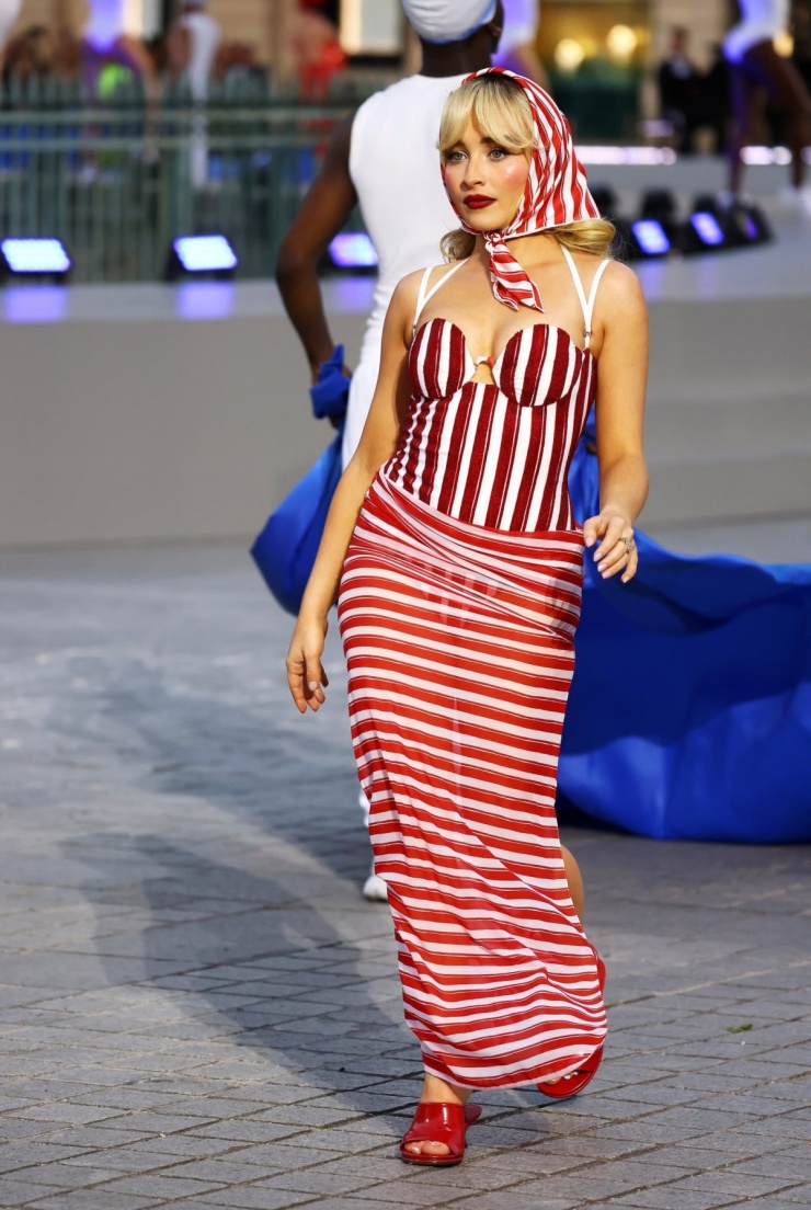 Ca sĩ Sabrina Carpenter catwalk trong bộ trang phục của Jacquemus theo phong cách cổ điển. Thiết kế tôn vinh môn bơi lội bằng bộ áo tắm đỏ kẻ sọc kết hợp khăn quấn mang hơi thở những năm 1940.
