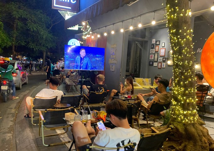 Nhiều nam giới đến các quán cà phê có màn hình lớn để tụ tập xem bóng đá trên đường Nguyễn Đình Thi, quận Tây Hồ, tối 16/6. Ảnh: Thanh Nga