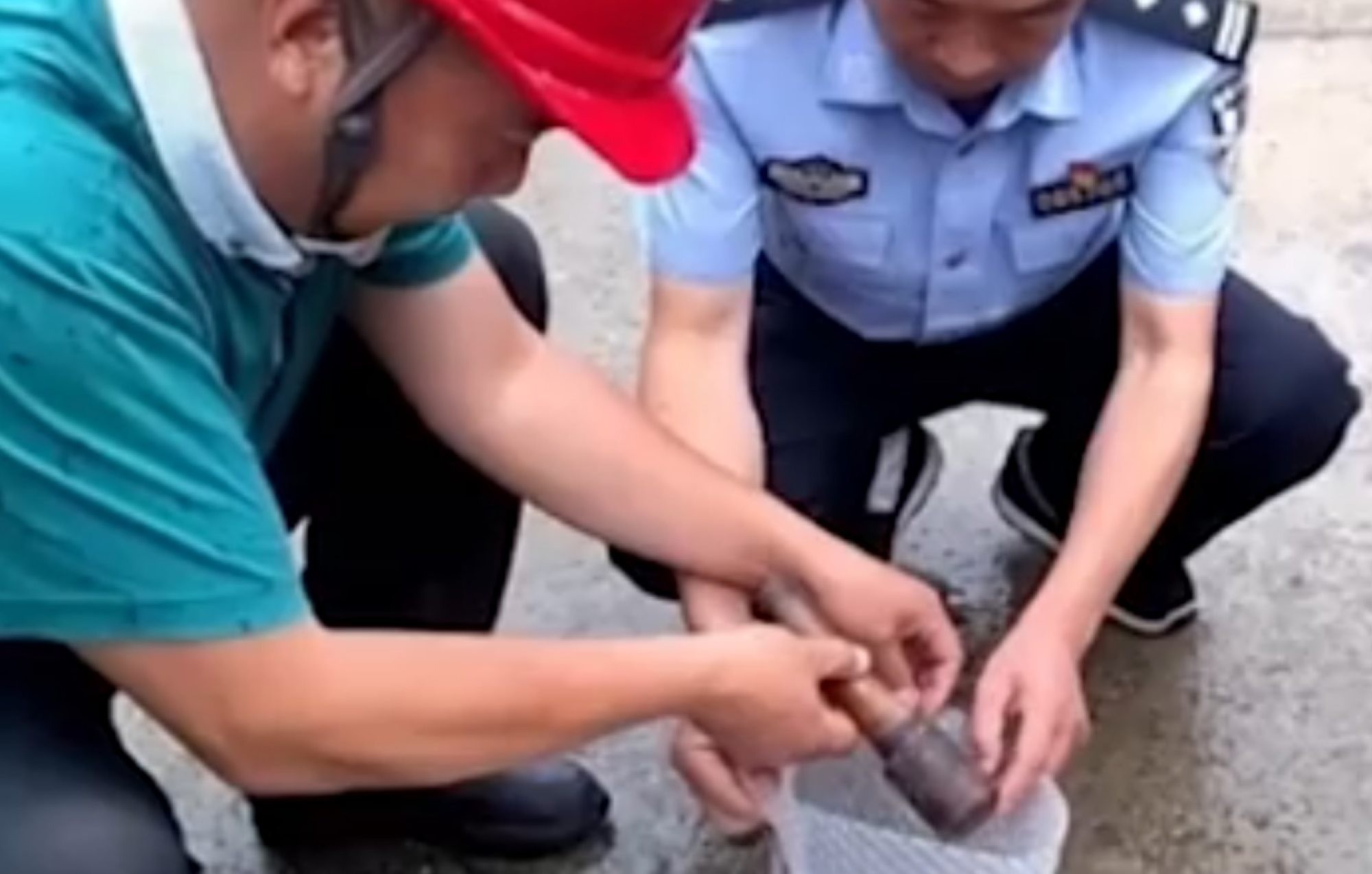 Công nhân làm việc ở nhà bà Qin bàn giao quả lựu đạn cho cảnh sát địa phương. Ảnh: Baidu