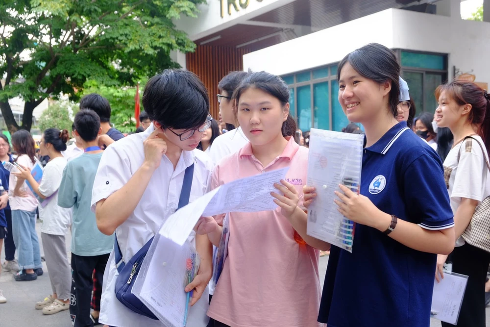 Học sinh Nguyễn Thảo Linh cùng các bạn so lại đáp án môn thi tiếng Anh. Ảnh: THANH TÚ