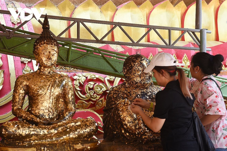 Người dân đến lễ chùa Wat Tham Suea thường mua vàng quỳ dán lên các bức tượng Phật trong chùa.