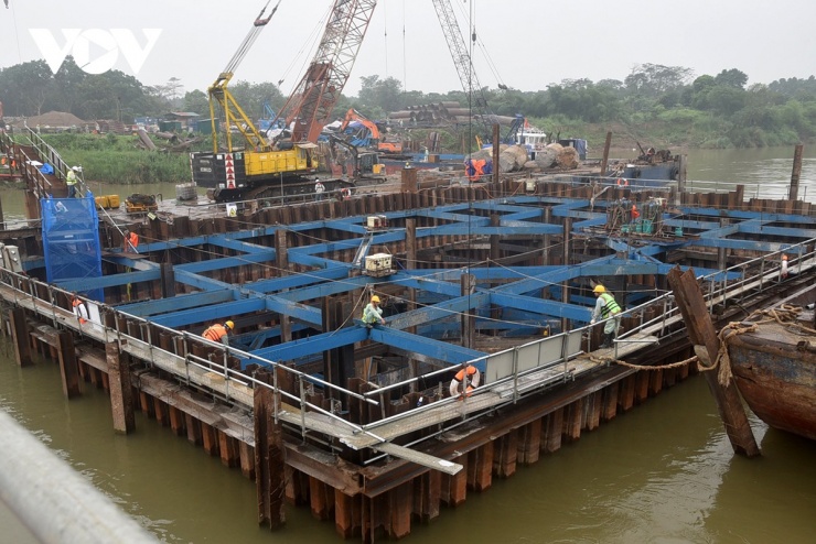 Theo đại diện chủ đầu tư, ở phía bờ Long Biên mặt bằng cơ bản thuận lợi hơn, cho phép nhà thầu triển khai thi công liên tục. Tuy nhiên, khu vực này lại phát sinh vướng mắc liên quan đến việc kết nối với trục đại lộ cảnh quan sông Hồng. Do chưa có quyết định chính thức về hướng tuyến, một số vị trí trụ cầu dẫn phải tạm dừng để chờ phương án, khiến tiến độ bị ảnh hưởng và nguồn lực thi công chưa thể phát huy tối đa.