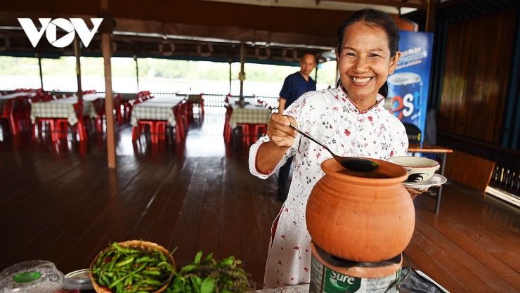 Đầu bếp nấu món Kaeng Som Yuan phục vụ du khách tại nhà hàng nổi bên cầu Song An.