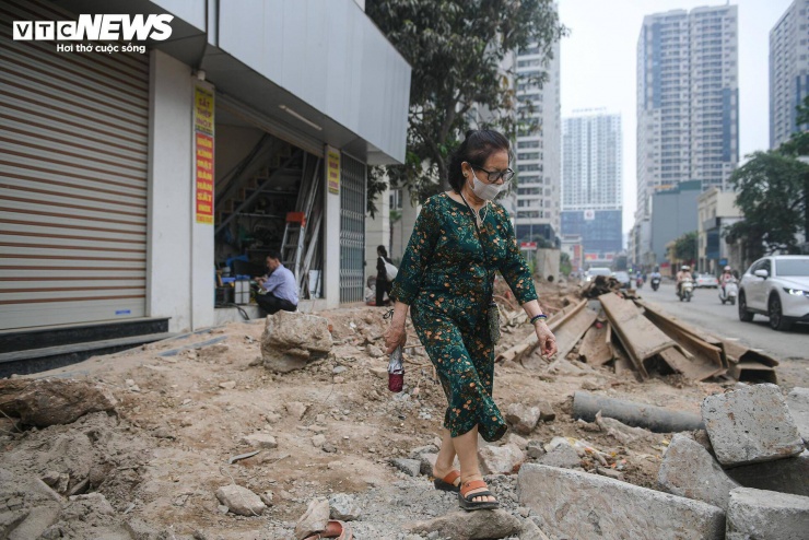 Hai bên tuyến đường tập trung nhiều khu chung cư và trường học, lượng người qua lại luôn đông. Trong điều kiện thi công dở dang, người dân buộc phải len lỏi qua các lối đi tạm bợ.