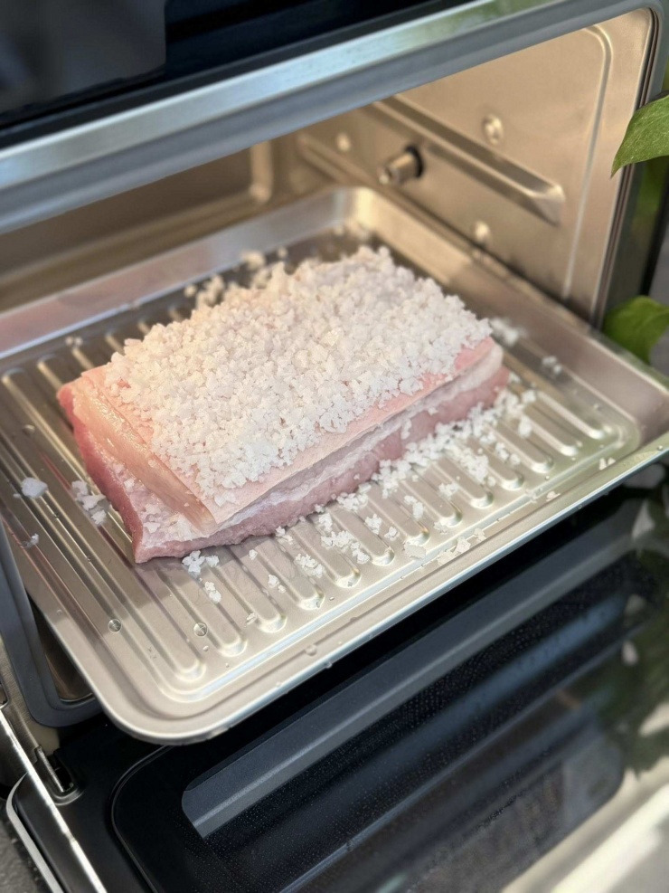 Phủ muối hạt kín mặt da heo nhưng nhớ là phải thấm cho khô da trước khi cho muối lên