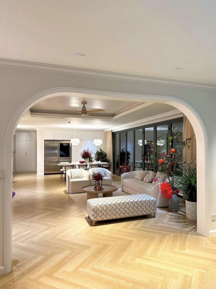 Không gian sinh hoạt chung trong penthouse của Đặng Thu Thảo được thiết kế theo lối mở, liên thông giữa phòng khách và khu bếp - ăn, tạo cảm giác rộng rãi. Sàn gỗ sáng màu kết hợp nội thất tông trắng - be giúp tổng thể hài hòa, ấm cúng.