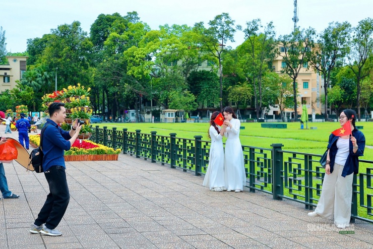 Các bạn trẻ chụp ảnh kỷ niệm trước Lăng Chủ tịch Hồ Chí Minh, mang theo cờ Tổ quốc trong dịp lễ 30/4.
