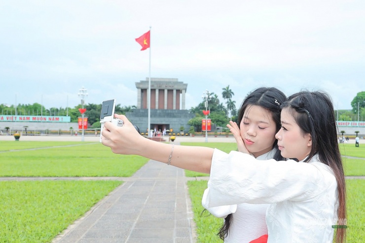 Các bạn trẻ tạo dáng, chụp ảnh trong không gian rực rỡ cờ hoa quanh khu vực Quảng trường Ba Đình.