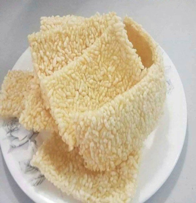 Cơm cháy vàng giòn, ăn kèm nước sốt thịt dê hoặc mỡ hành, ruốc, tạo nên hương vị đậm đà đặc trưng.