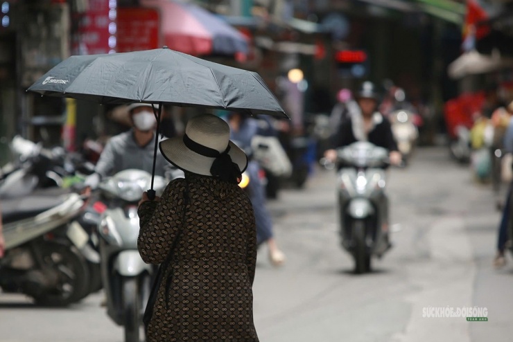 Ô che nắng là vật "bất li thân" của người đi bộ trên phố Hà Nội.