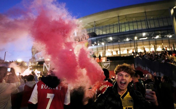 Người hâm mộ Arsenal đốt pháo sáng bên ngoài sân Emirates, nơi hàng nghìn CĐV đã tập trung ăn mừng