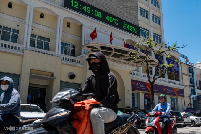 Biển hiển thị trên đường Láng Hạ ghi nhận mức nhiệt 40 độ C lúc 12h ngày 25/5. Đường phố vắng vẻ, người có việc cần kíp phải ra đường đều trùm kín mít. Ảnh:Thế Bằng