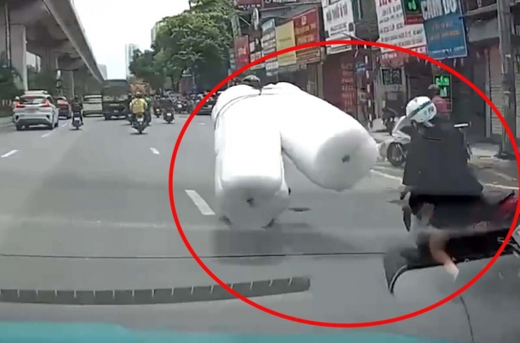 Chở hàng cồng kềnh va chạm khiến người phụ nữ ngã xuống gầm xe ô tô - 1