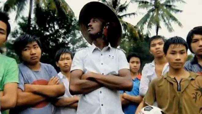 K'Naan đội nón lá bên những cậu bé xứ biển xuất hiện trong MV "Wavin’ Flag". Ảnh chụp màn hình
