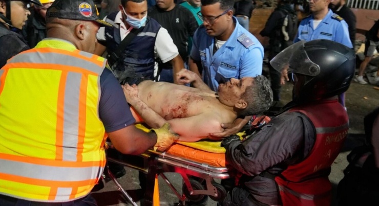 Nhân viên cứu hộ khiêng một người đàn ông bị thương sau trận động đất ở Caracas.