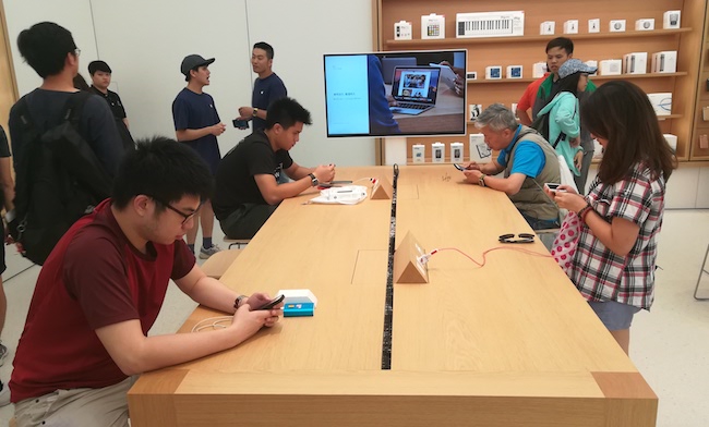 Bên trong cửa hàng, Apple trang bị nhiều bàn, ghế bằng gỗ cao cấp màu vàng óng với thiết kế vuông vức.