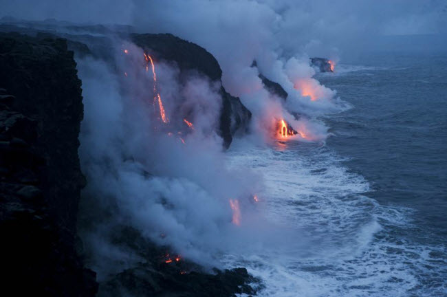 Dung nham nóng chảy xuống biển trong công viên núi lửa Hawaii, Mỹ.