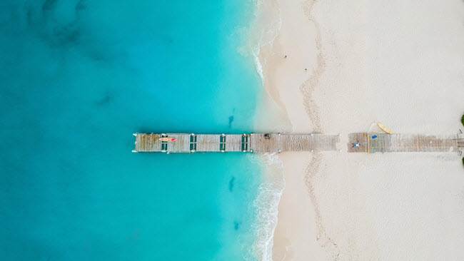 Grace Bay, Turks &amp; Caicos: Bãi biển này đã giành được nhiều giải thưởng nhờ bãi cát trắng và nước trong đến kinh ngạc. Cùng với khách sạn tiêu chuần 5 sao và phong cảnh đẹp, nơi đây là điểm đến lý tưởng cho một kỳ nghỉ sang trọng, lặn ống thở hay lặn bình khí.