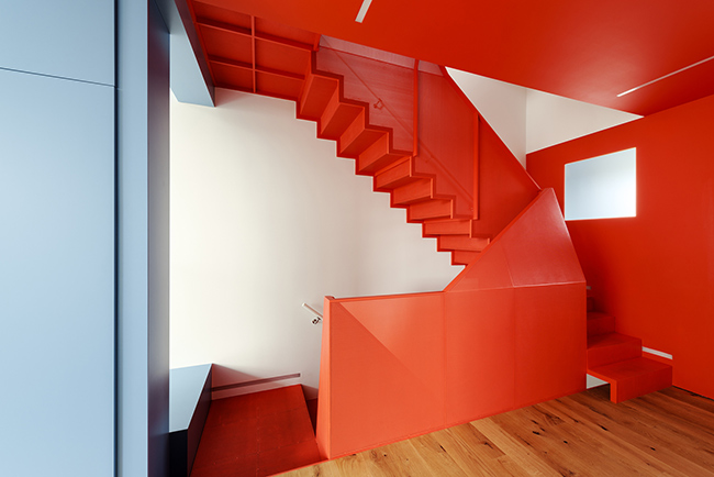 Góc cầu thang hai tầng nổi bật với sắc đỏ rực rỡ