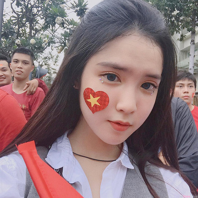 Mới đây, hình ảnh xinh đẹp của một fan girl bóng đá Việt Nam được dân mạng đua nhau truyền tay. Diện sơ mi trắng đơn giản nhưng cô nàng vẫn hút hồn người nhìn bởi gương mặt xinh  như búp bê. 