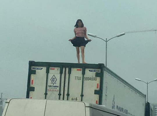 Người phụ nữ mặc váy quậy &#34;tưng bừng&#34; trên nóc thùng xe container - 1