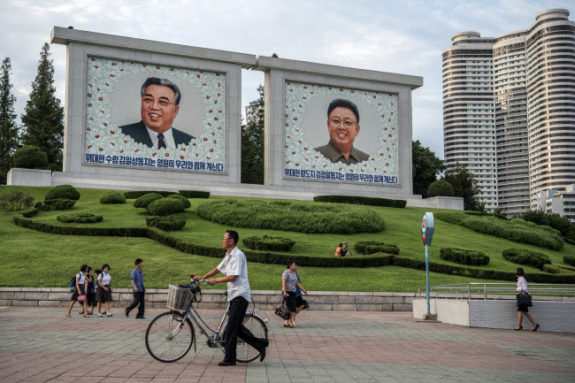 Người dân đi qua bức chân dung khổng lồ của cố lãnh đạo Triều Tiên Kim Jong-il và lãnh tụ&nbsp;Kim Il-sung &#40;Kim Nhật Thành&#41;&nbsp;ở thành phố Bình Nhưỡng.