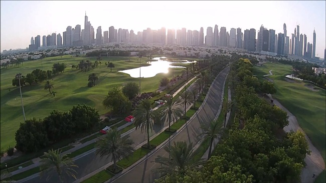 Con đường rộng rãi, bên cạnh là sân golf xanh mướt ở Emirates Hills