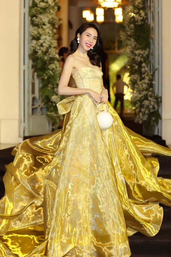 Theo đuổi phong cách công chúa sang chảnh, Thủy Tiên chọn chiếc váy cúp ngực màu vàng, bồng bềnh. Gam màu vàng rực rỡ kết hợp với chất liệu vải bắt sáng giúp cho bà xã Công Vinh nổi bật hơn bao giờ hết. Cô còn chịu chơi khi kết hợp cùng chiếc túi&nbsp; "quả địa cầu" của Chanel giá gần 300 triệu đồng.