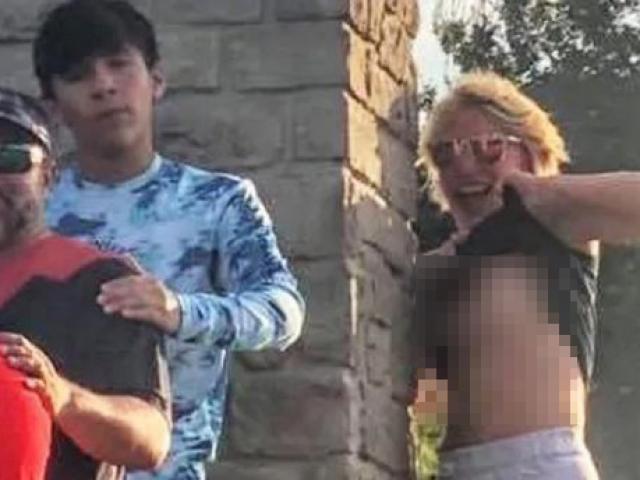 Vén áo lộ ngực phá bức ảnh chụp gia đình, cô gái lạ bị tố cáo với cảnh sát