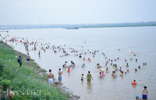 Bãi cát kéo dài chừng 500m nằm giữa hai cây cầu Thăng Long và Nhật Tân&nbsp;(Hà Nội) những ngày đầu hè trở thành bãi tắm tự phát, hằng ngày thu hút nhiều người lớn, trẻ nhỏ tới tắm mát.