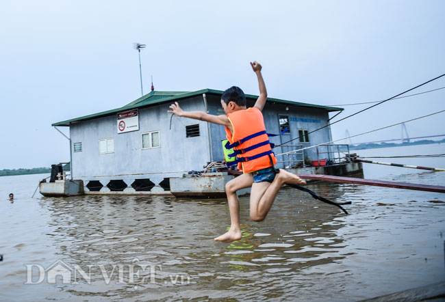 Các em thiếu niên tận dụng thuyền đò để nhảy sông, đùa nghịch.