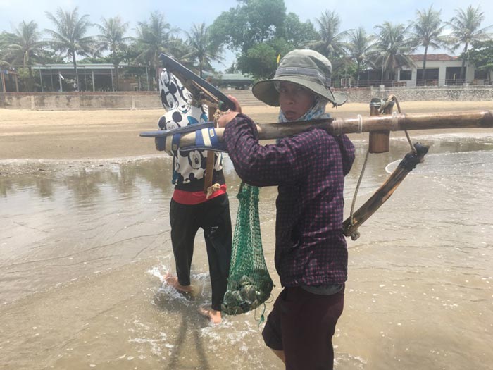 Sau nhiều giờ ngâm mình ở dưới nước biển, người cào ngao ra về với thành quả hơn 3kg ngao. Ảnh: Cảnh Thắng.