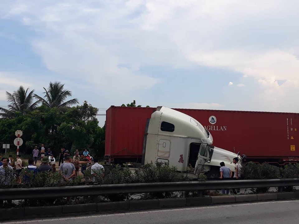 Xe container đâm vào hàng rào chắn quay ngang đường gây ùn tắc giao thông. Ảnh: H.N